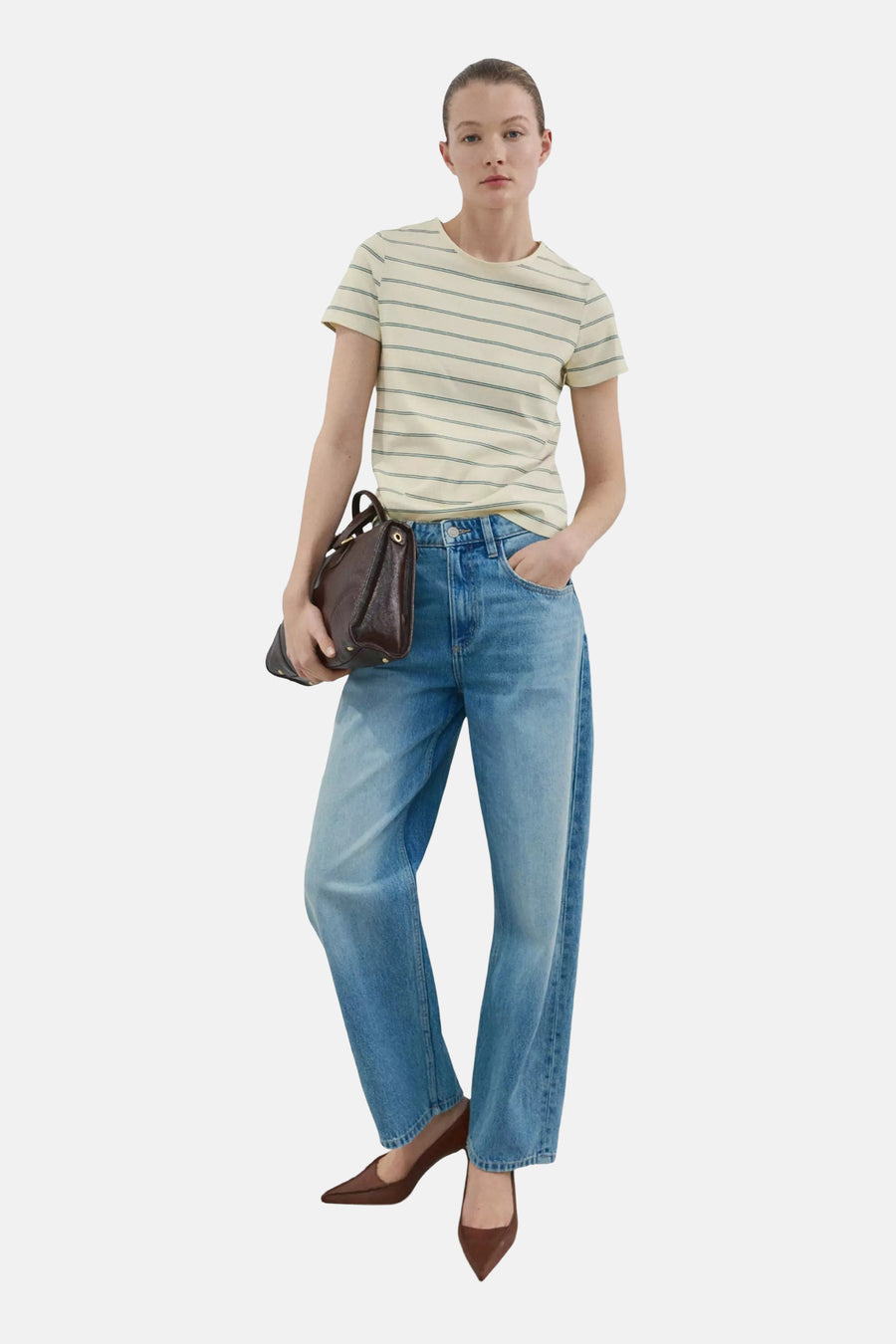 T-shirt jaune de MANGO à fines rayures vertes, combiné avec un jean bleu et des accessoires marron.