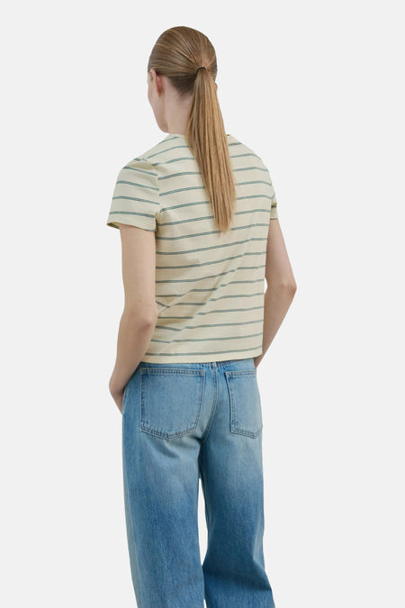 Lichtgeel T-shirt van MANGO met korte mouwen en groene strepen, gezien vanaf de rug van een model in een blauwe spijkerbroek.