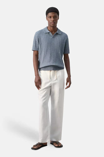 Blauwe gebreide polo met ribstructuur van MANGO, gedragen met witte broek en slippers, front view