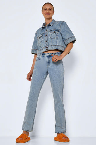 Lichtblauwe denim straight jeans van NOISY MAY, gecombineerd met een bijpassende denim jas en oranje slippers.

