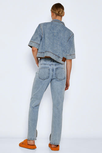 Straight jeans van lichtblauw denim van NOISY MAY, met split aan de zijkant en gedragen met een denim jasje en oranje pantoffels.