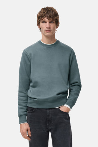 Pull-over bleu avec col rond de MANGO, vu de dos, associé à des jeans foncés.