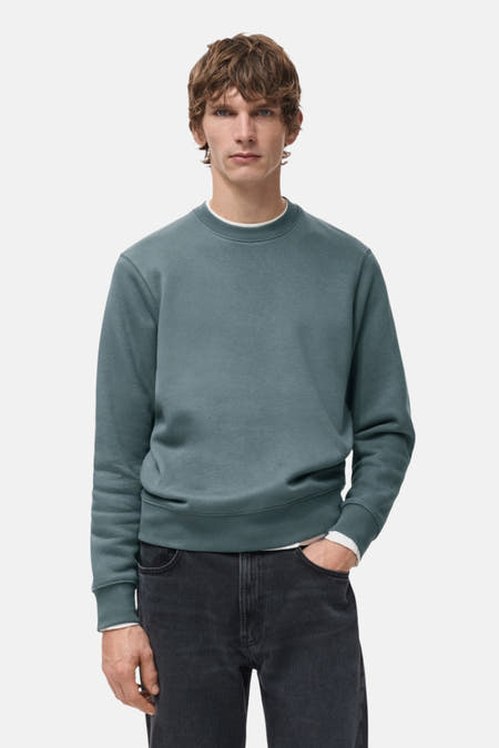 Blauwe sweater met ronde hals van MANGO, gedragen met een zwart-grijze jeans.