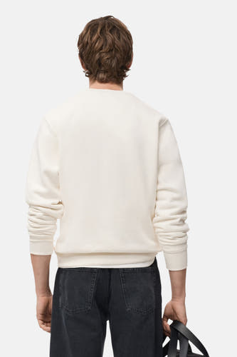Witte sweater van MANGO, gezien van achteren, met lange mouwen en donkere jeans.
