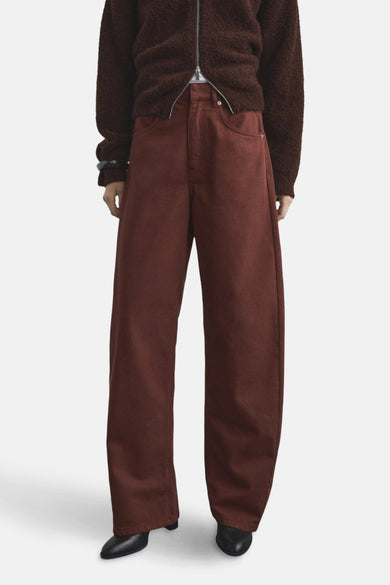 Bruine gekleurde jeans van MANGO, met wijde pijpen en gedragen met een bruin vest.
