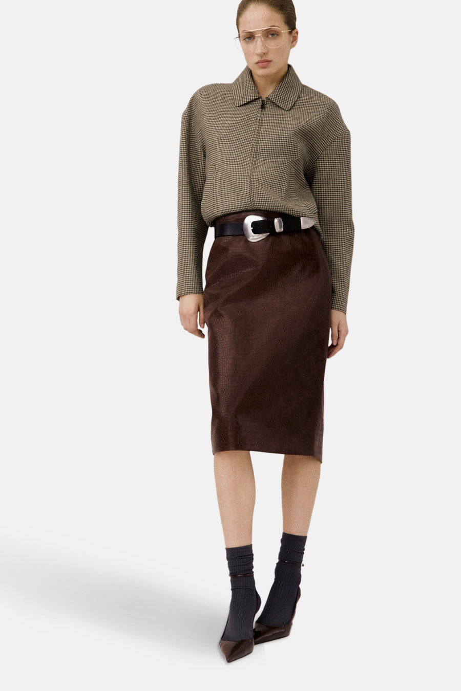 Multikleurige blazer van MANGO, met een ruitjespatroon, gedragen met een bruine rok met krokodillenhuidtextuur.