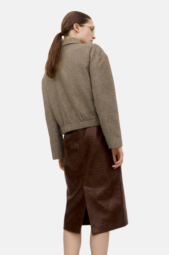 Multikleurige blazer van MANGO, met een ruitpatroon, gecombineerd met een bruine rok van imitatie krokodillenleer.
