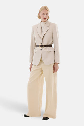 Jean de couleur beige de MANGO, stylisé avec un blazer ajusté et une ceinture.