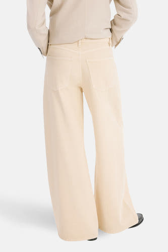 Beige gekleurde jeans van MANGO, met wijde pijpen, achterzakken en een lichtgekleurde blazer.
