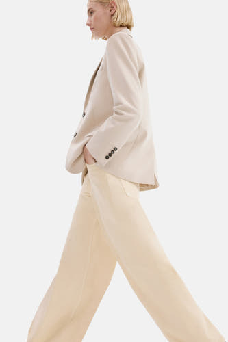 Jean de couleur beige de MANGO, avec jambes larges et un style minimaliste.