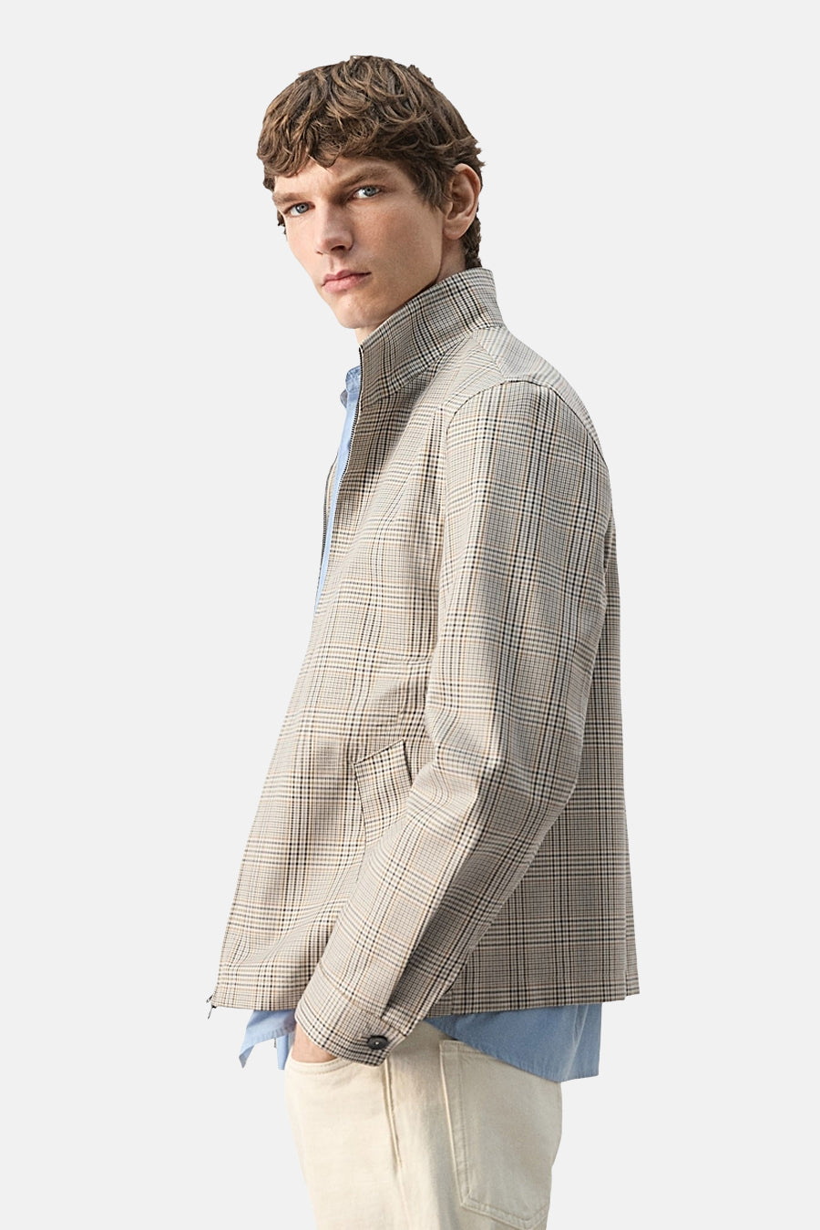 Kort multicolor jas van MANGO met ruitpatroon, opstaande kraag en lichte broek.