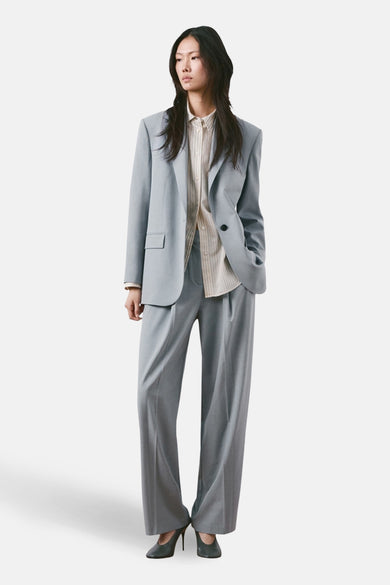 Pantalon de costume bleu de MANGO, à jambes larges et associé à une chemise rayée et des talons hauts.