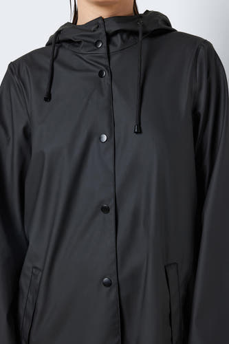 Gilets de pluie noirs de DROPLETS, avec un capuchon à cordon et des boutons noirs, et des poches à l'avant.