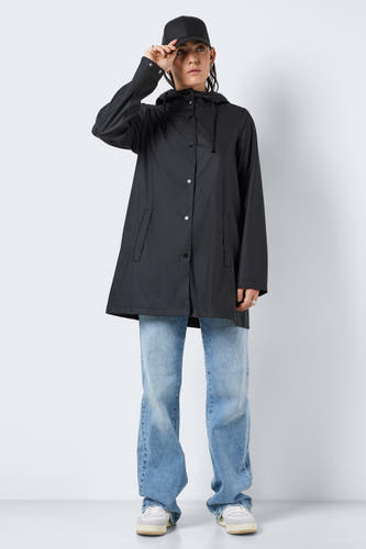 Manteaux de pluie noirs de DROPLETS, avec capuchon, portés avec des jeans bleus et des baskets crème.