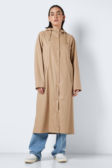 Beige regenjas van DROPLETS, met capuchon en knoopsluiting, gedragen met blauwe jeans en witte sneakers.
