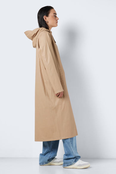 Beige regenjas van DROPLETS, gedragen met jeans en sneakers, in zijaanzicht.

