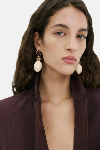 Multicolor oorringen van MANGO, met een bruine kraal en een wit geweven hanger.
