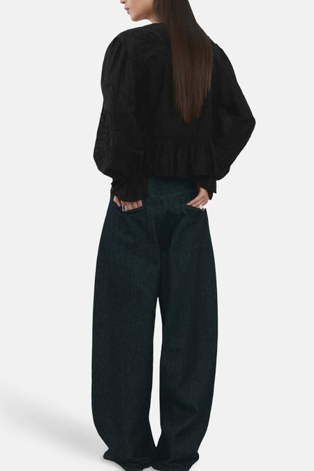 Zwarte blouse met lange mouwen van MANGO, met geborduurde details en een geplooid detail aan de onderkant.