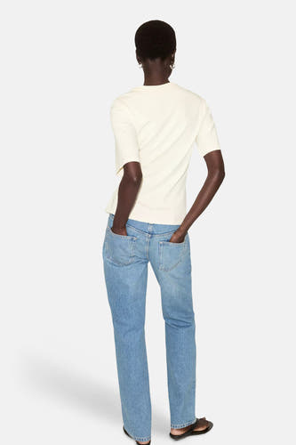 Gele korte mouwen t-shirt van MANGO, achterzijde, gladde stof, model met blauwe jeans en sandalen