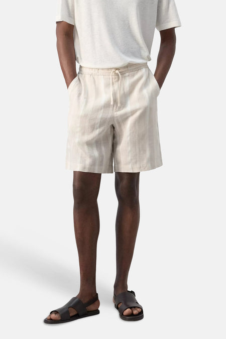 Beige Bermuda van MANGO met verticale strepen, trekkoord taille, gedragen met een wit T-shirt en donkere sandalen.