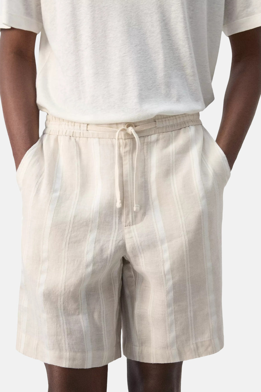 Bermuda beige à rayures de MANGO avec cordon de serrage et taille élastique, portée par le mannequin.