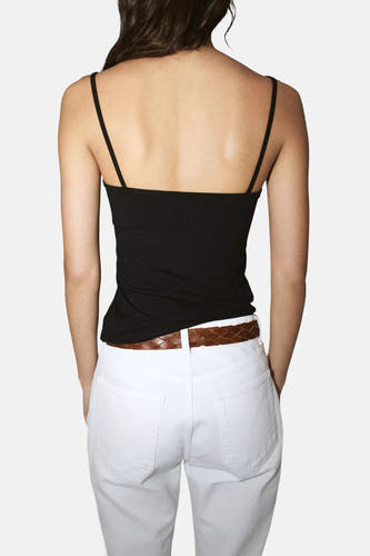 Zwarte spaghettibandjes top van MANGO, achterkant, met slanke bandjes en strakke pasvorm, gedragen met witte broek en bruine riem