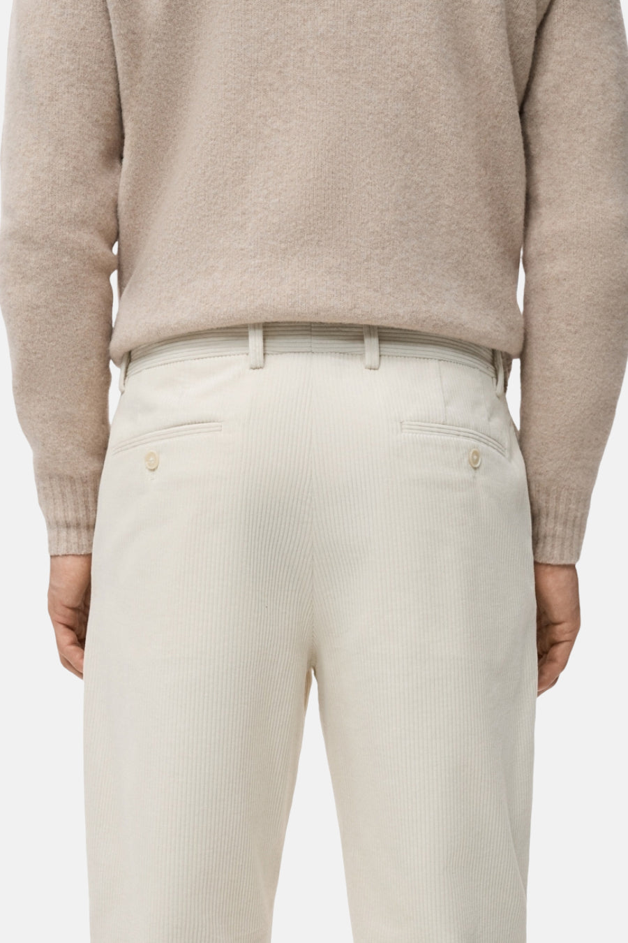 Ecru broek van MANGO, corduroy textuur, met riemlussen en achterzakken zichtbaar van achteren.
