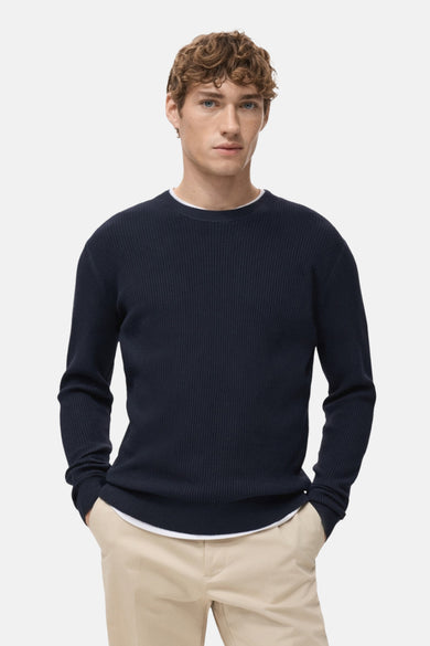 T-shirt bleu avec col rond de MANGO, dos visible avec une texture côtelée, porté avec un pantalon kaki.