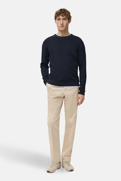 T-shirt bleu avec col rond de MANGO, porté avec un pantalon beige et des baskets en cuir.