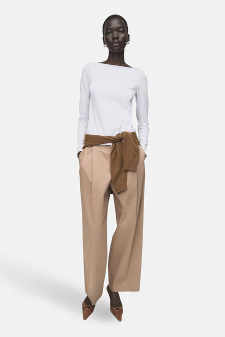 Blauw T-shirt met lange mouwen van MANGO, gedragen met bruine broek en sjaal.