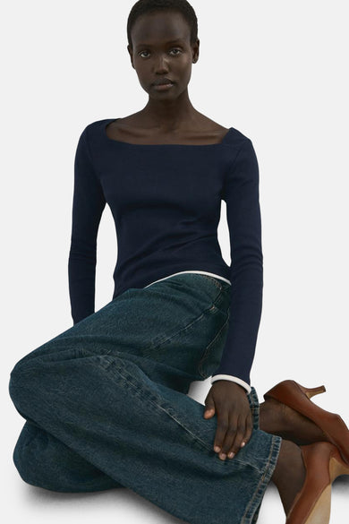 Blauw T-shirt met lange mouwen van MANGO, gedragen met wijde jeans en bruine pumps.