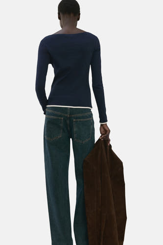 Blauw T-shirt met lange mouwen van MANGO, gezien van achteren, gecombineerd met jeans en een bruin jasje.
