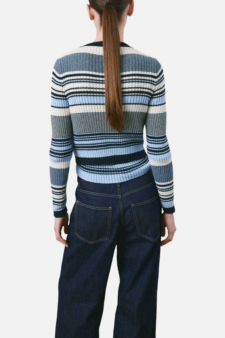 Multikleurig gilet van MANGO, met horizontale strepen en een strak silhouet, gecombineerd met een donkere denim broek.
