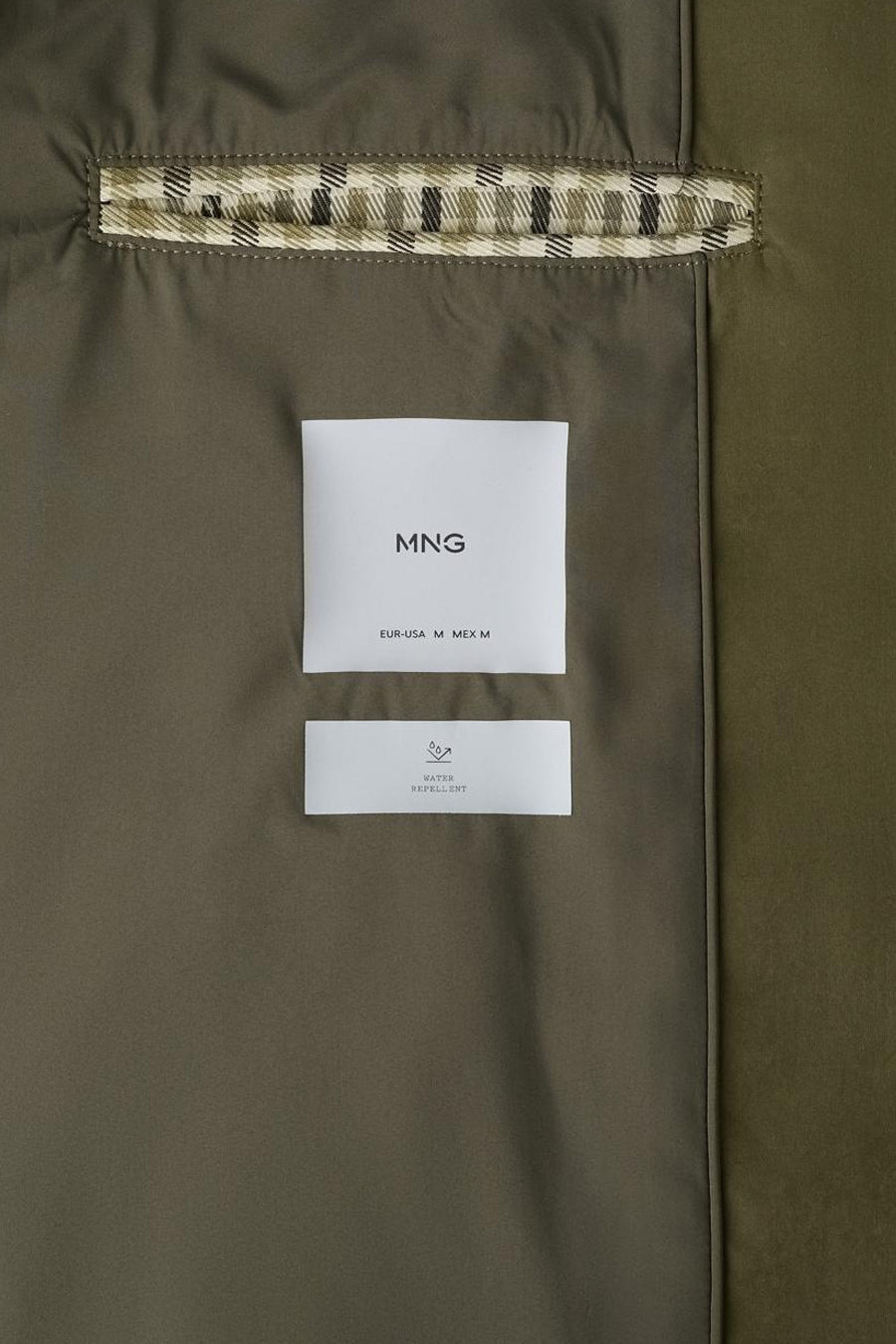 Long manteau kaki de MANGO, avec étiquette visiblement déperlante et détail à carreaux au col.