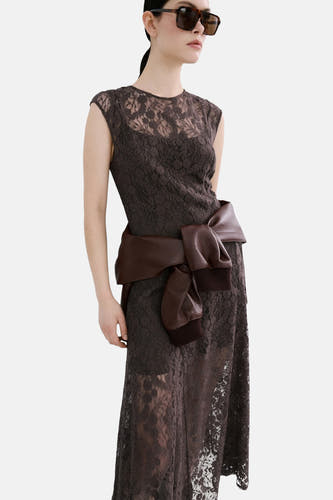 Robe sans manches marron de MANGO, avec une superposition de dentelle à fleurs, combinée avec une veste en cuir marron et des bottes noires.