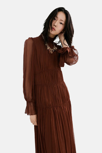 Robe marron à manches longues de MANGO, avec des plis, un col montant et une chaîne dorée.
