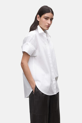 Chemise blanche à manches courtes de MANGO, vue de dos avec de longs cheveux foncés.