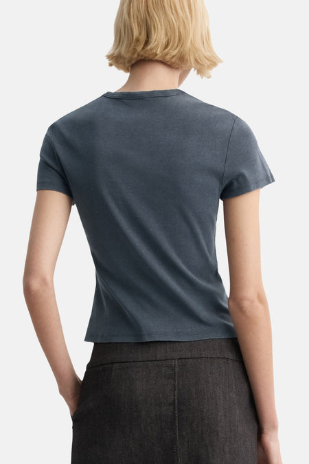 Blauwe top van MANGO, gezien van achteren, gecombineerd met een donkere broek.