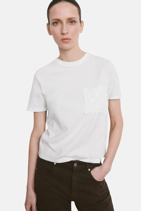 T-shirt blanc de MANGO, vu de dos, combiné avec un pantalon ample marron foncé.