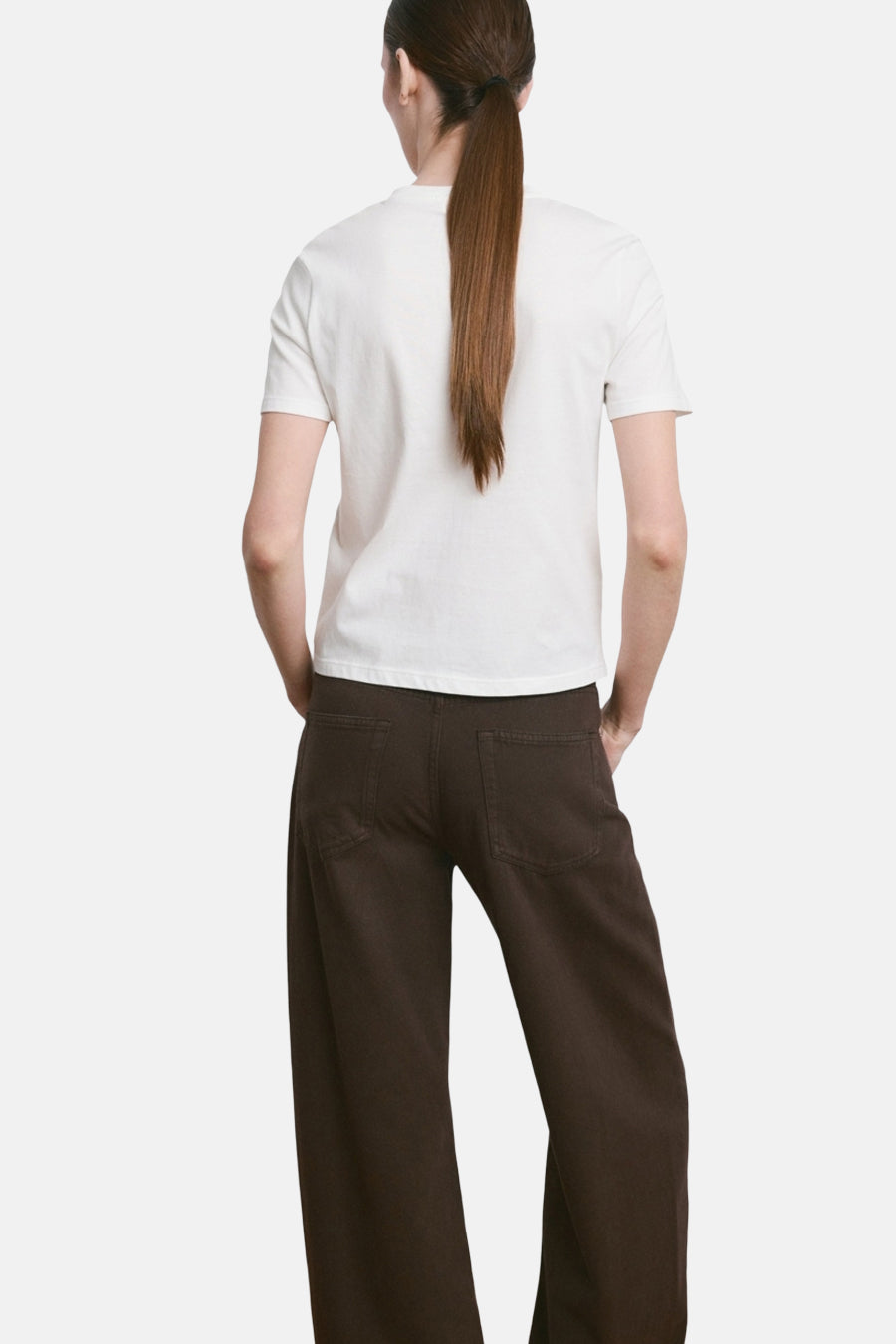 Wit T-shirt van MANGO, gezien van achteren, gecombineerd met een losse donkerbruine broek.