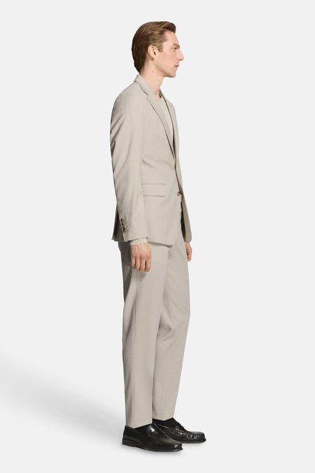 Beige blazer van MANGO, in een effen kleur, gedragen over een bijpassend shirt en pantalon, in zijaanzicht.