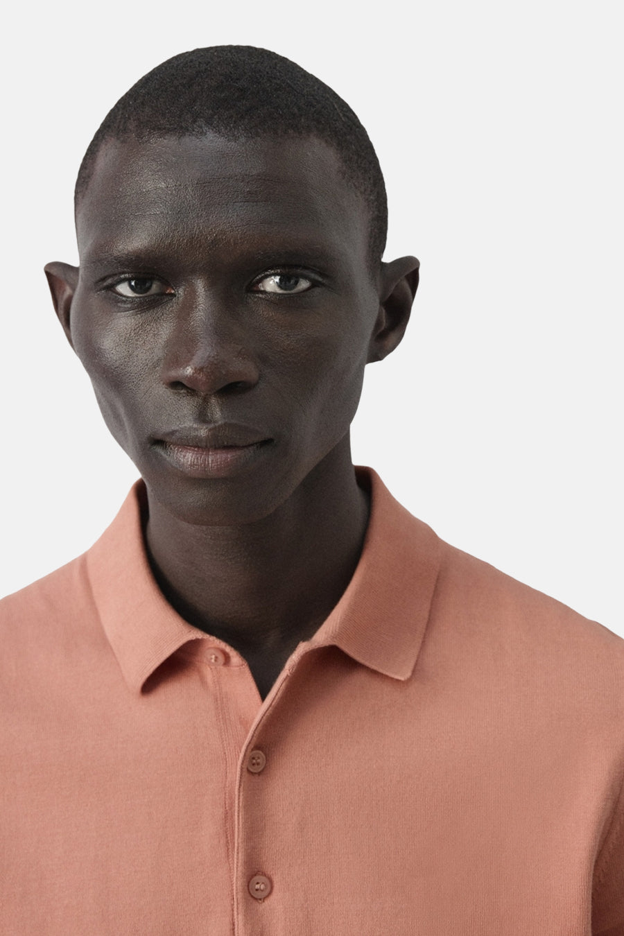 Polo orange MANGO, à manches courtes et fermeture boutonnée, gros plan.