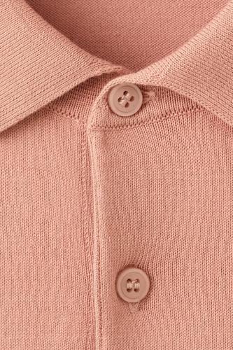 Polo orange de MANGO, avec une texture tricotée et un col classique à boutons.