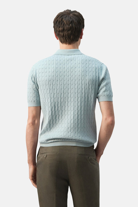 Blauwe polo van MANGO met kabelpatroon en korte mouwen, gezien van de achterkant.