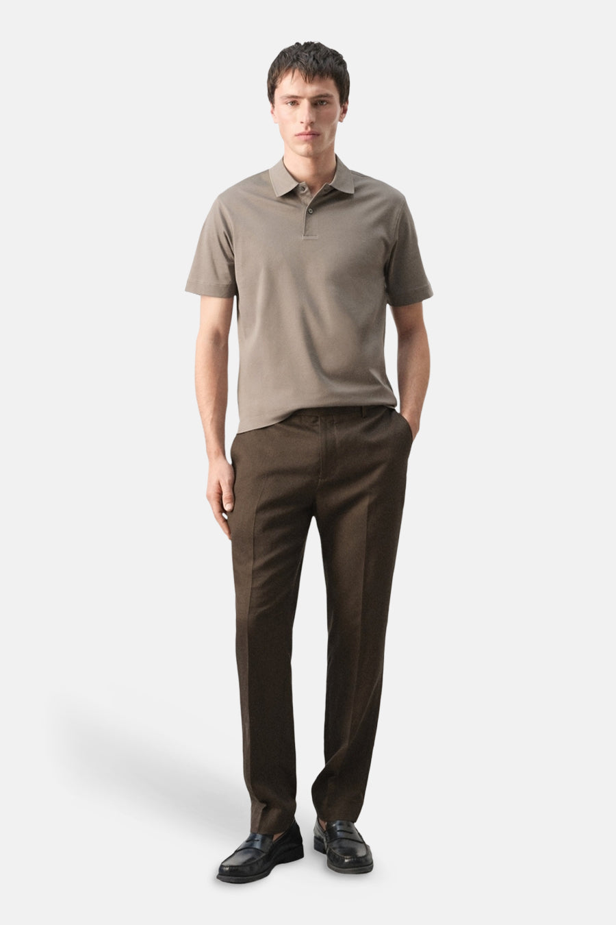 Bruine polo van MANGO, met korte mouwen en gedragen met bruine pantalon en zwarte loafers.