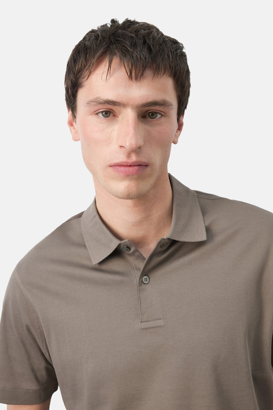 Bruine polo van MANGO, close-up van een man die een taupekleurige polo met korte mouwen draagt.
