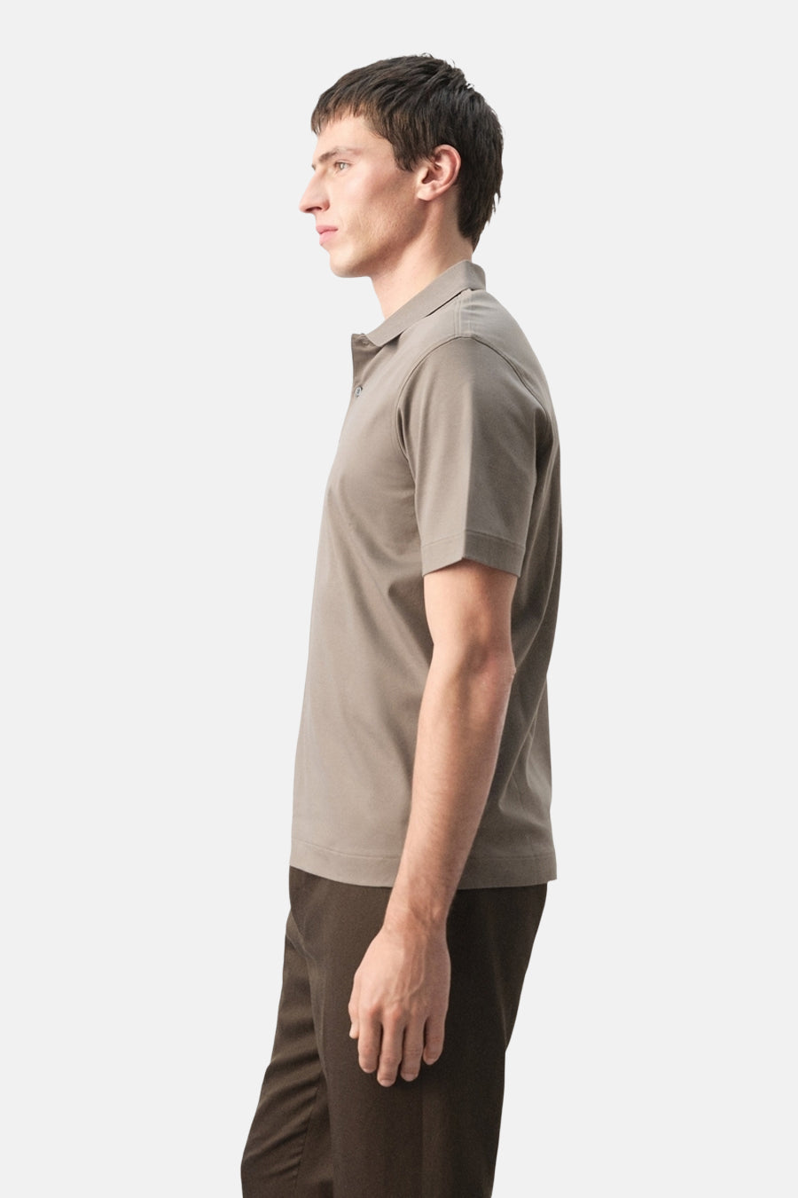 Bruine polo van MANGO, in zijaanzicht, gedragen met een donkere broek.
