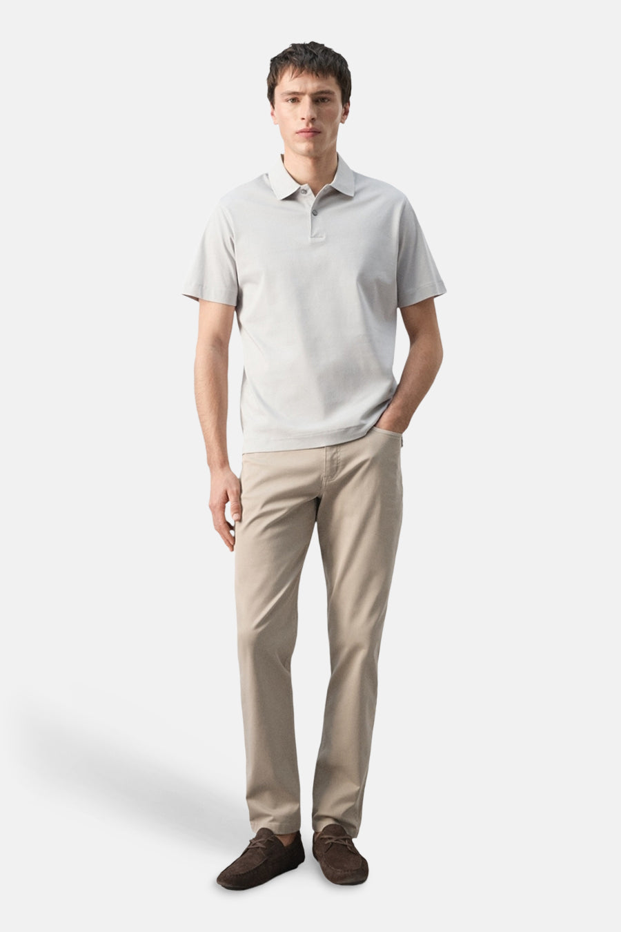 Grijze polo van MANGO, gedragen met een kaki broek en bruine mocassins, staand gepresenteerd.
