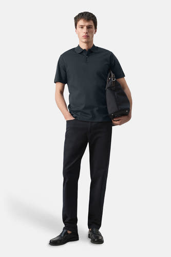 Blauwe polo van MANGO, gedragen met een zwarte broek, loafer schoenen en een zwarte tas.