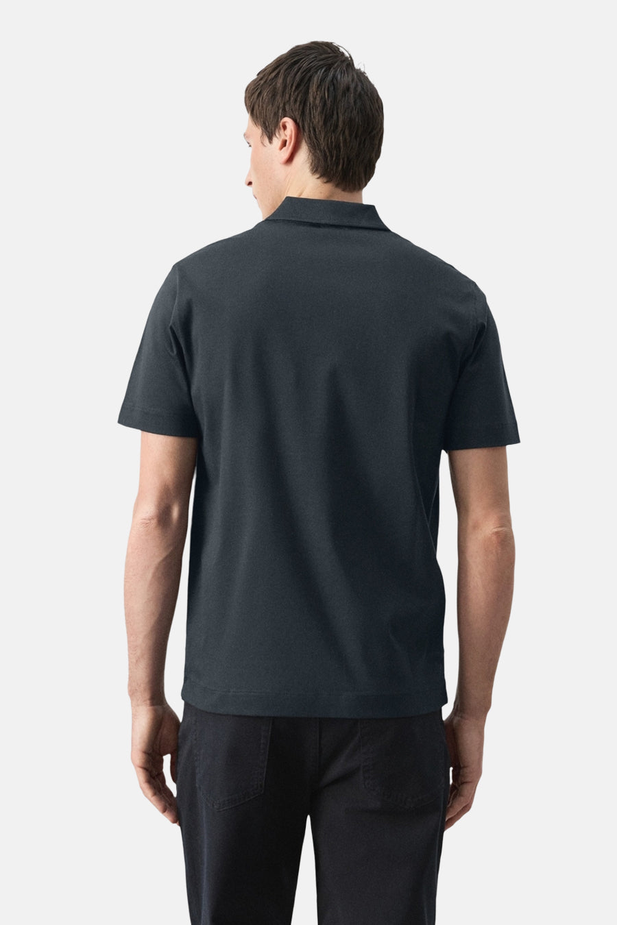 Blauwe polo van MANGO, met korte mouwen, gezien van achteren en gecombineerd met een zwarte broek.
